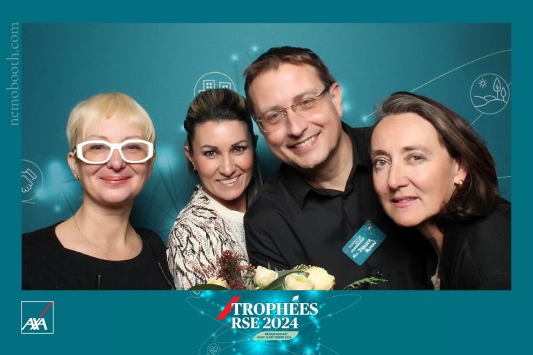 Quatre amis posent et sourient au photobooth lors d'une soiree
